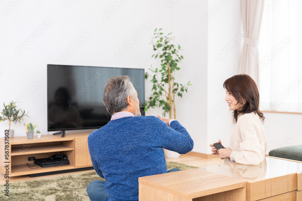 テレビを見るミドル 夫婦 後ろ姿 テレビを見るミドル 夫婦 後ろ姿