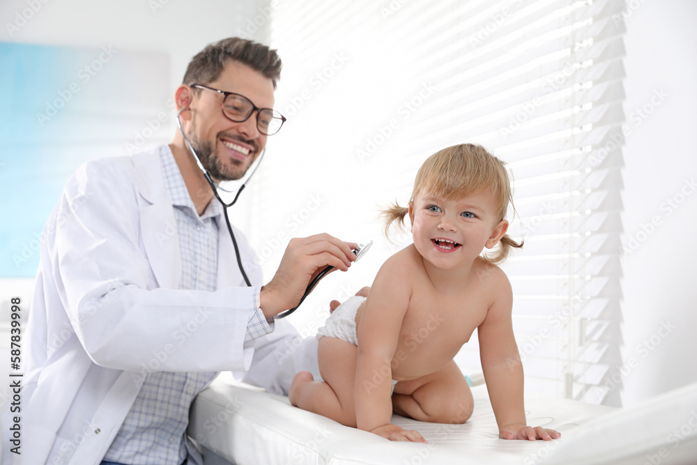 Pediatrician examining baby with stethoscope in clinic Pediatrician examining baby with stethoscope in clinic