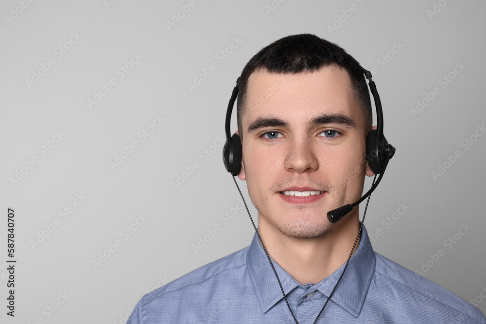 Hotline operator with headset on light grey background, space for text Hotline operator with headset on light grey background, space for text