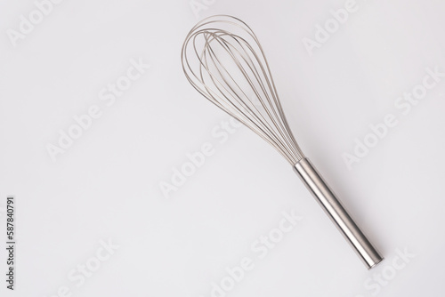 Stainless steel egg whisk on white background. cooking tool.