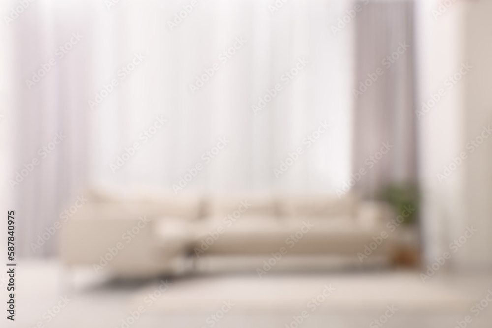 Blurred view of comfortable sofa and window with beautiful curtains in room. Interior design