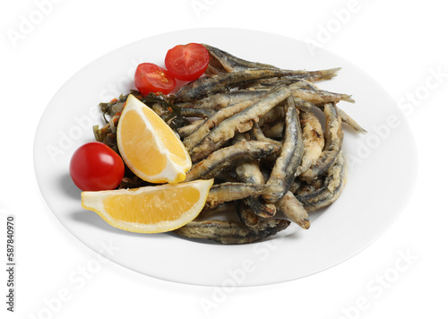 Plate with delicious fried anchovies, cherry tomatoes and slices of lemon isolated on white