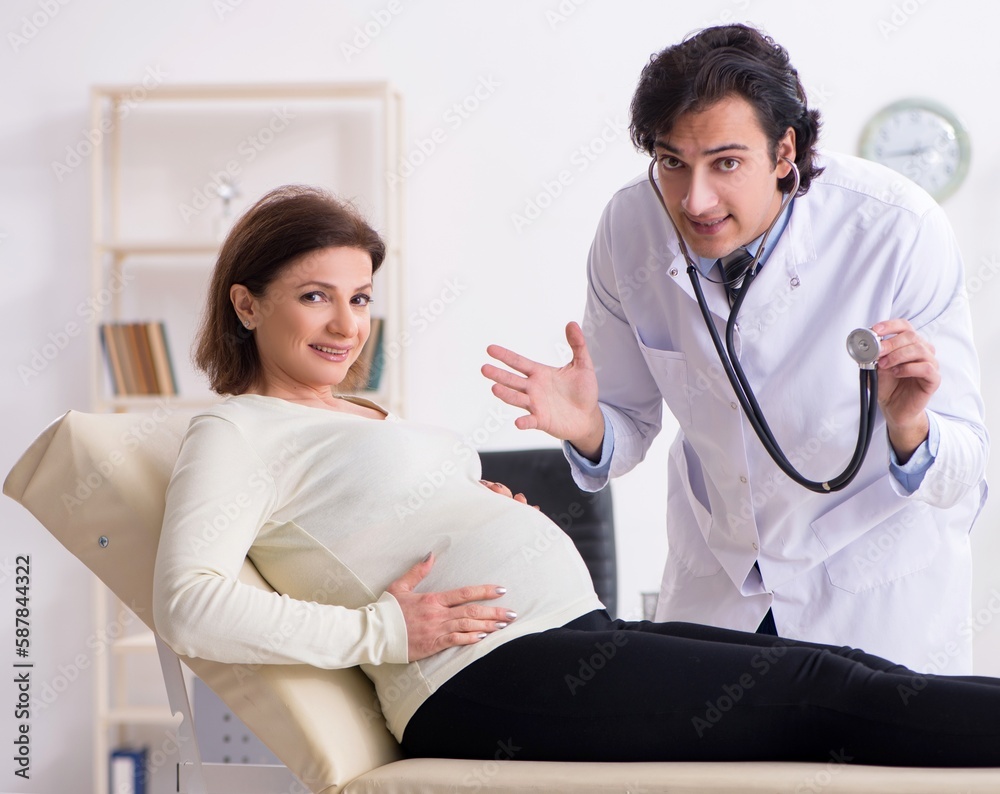 Old pregnant woman visiting young male doctor Old pregnant woman visiting young male doctor