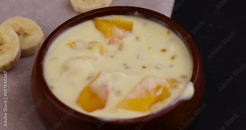 natural banana yogurt of yellow color with the addition of pieces of fruit and persimmon, natural yogurt with pieces of fruit and banana flavor natural banana yogurt of yellow color with the addition of pieces of fruit and persimmon, natural yogurt with pieces of fruit and banana flavor