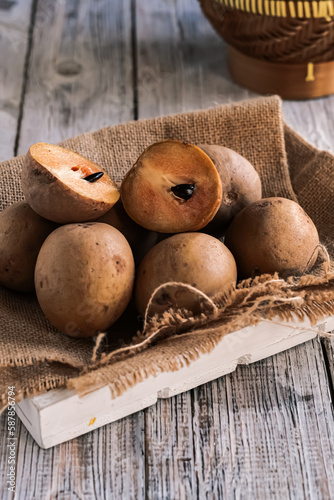sawo or sapodilla fruit in basket on the wooden table
 photo