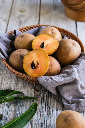 sawo or sapodilla fruit in basket on the wooden table
