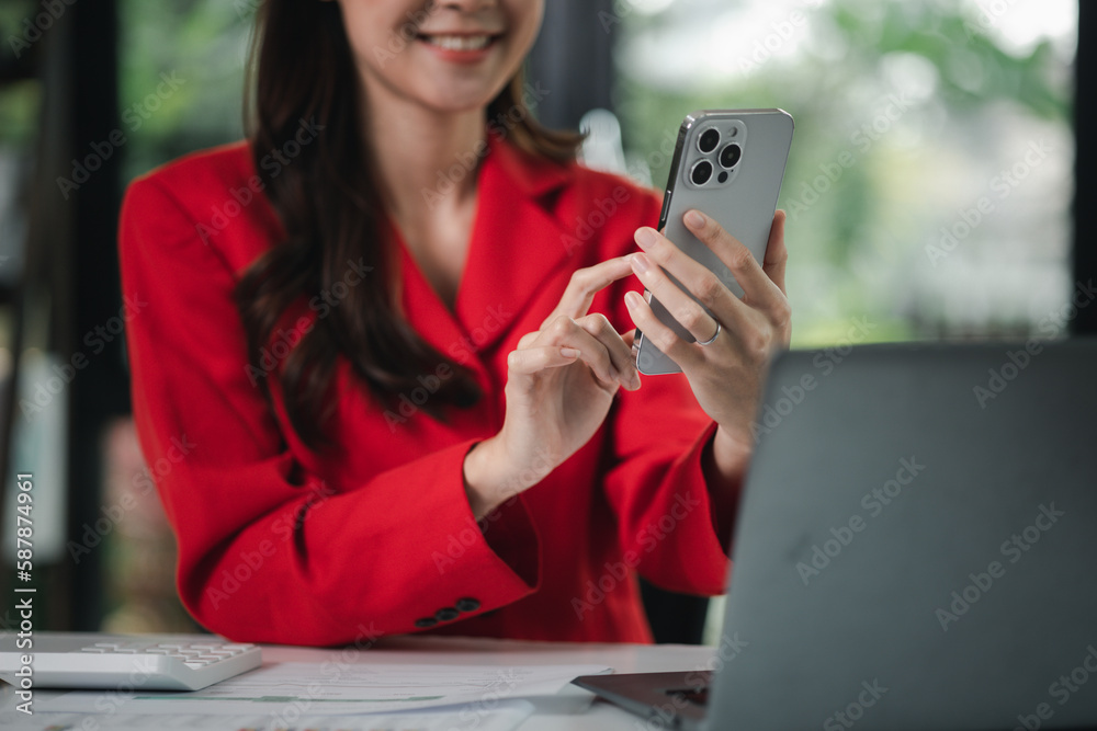 young businesswoman looking at financial information from a mobile phone, she is checking company financial documents, she is a female executive of a startup company. Concept of financial management. young businesswoman looking at financial information from a mobile phone, she is checking company financial documents, she is a female executive of a startup company. Concept of financial management.