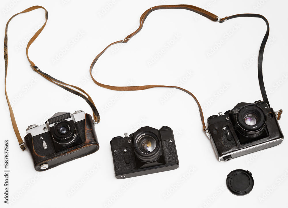 three Old, aged film cameras in black leather cases isolated on white background. 3 Vintage soviet union photo cameras. made in USSR.