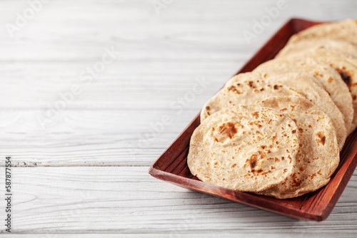 Homemade Indian Traditional Flatbread called Chapati on a white wooden background. Baked indian flatbread. Copy space photo