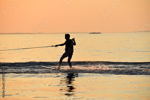 silhouette of a person on a wake surf board