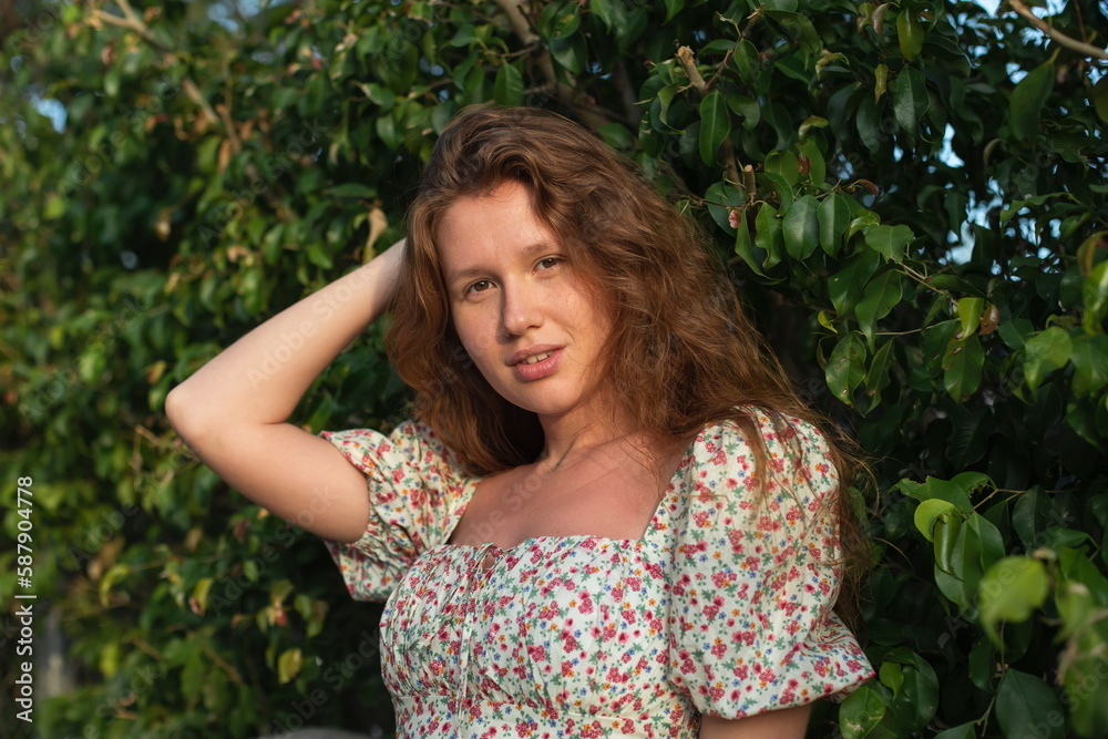 Portrait of beautiful young woman in dress is enjoy summer or spring day on natural green natural wall background in garden or forest on nature Portrait of beautiful young woman in dress is enjoy summer or spring day on natural green natural wall background in garden or forest on nature