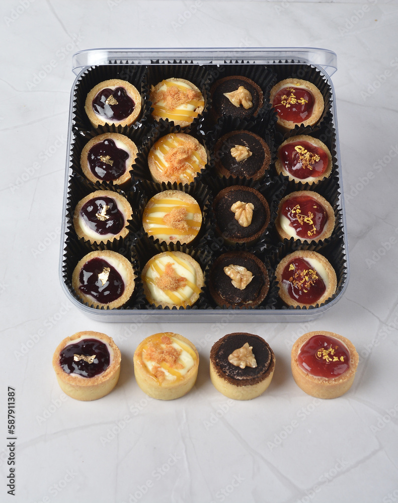 mini bake cute crisp creamtart with colourful flavour like chocolate coffee walnut, golden blueberry, strawberry osmanthus, mango vanilla in crystal plastic box on white marble pastry halal party menu