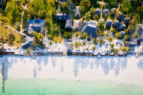 Immerse yourself in the natural beauty of Zanzibar Island's tropical beach, with its white sand, swaying palm trees, and crystal-clear turquoise waters against a blue sky with fluffy clouds on a sunny © Sebastian