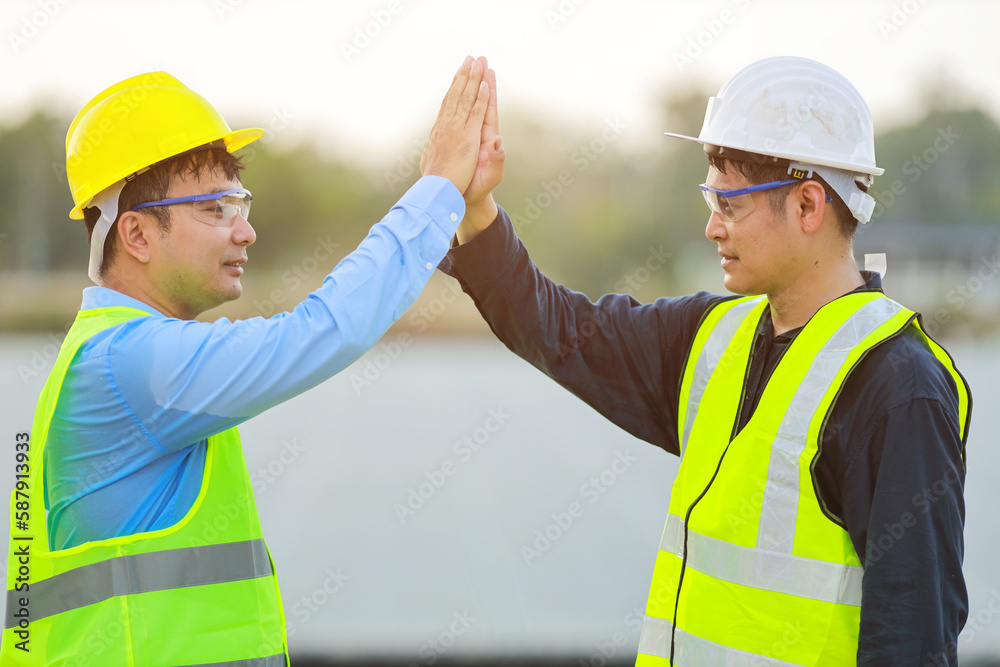 Two professional engineers discussing and glad in success during working at the panels at solar energy on buoy floating.Eco technology for electric power in industry.