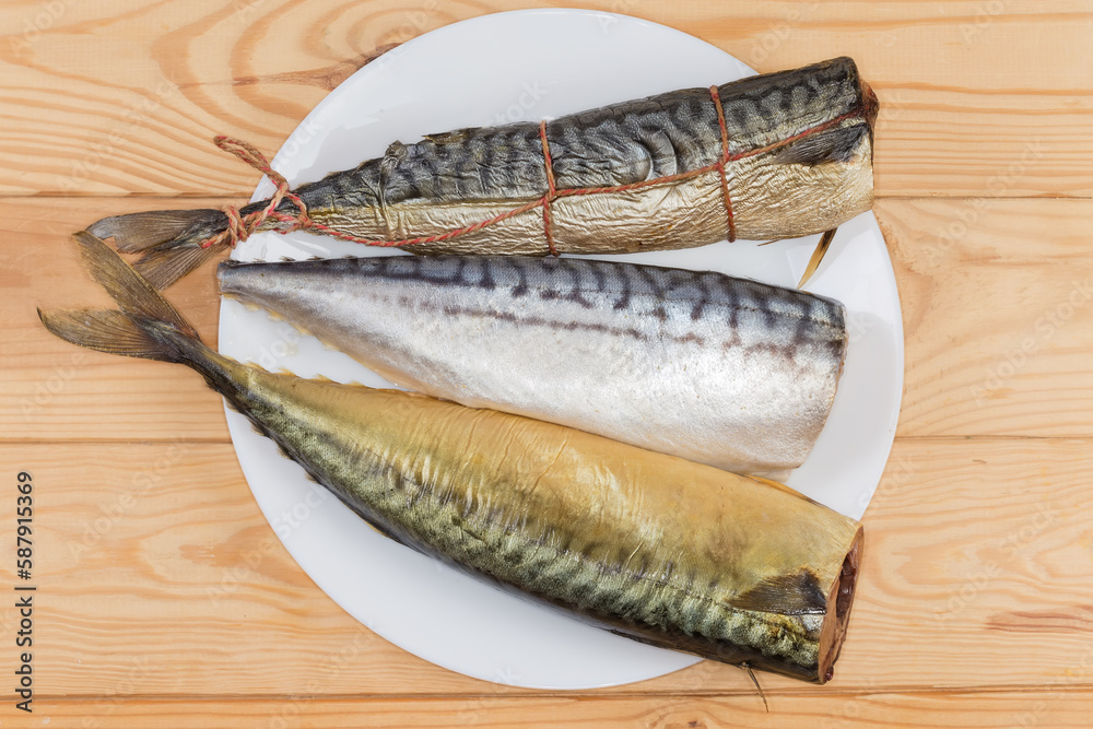 Hot-smoked, cold-smoked, salted mackerels on dish, top view Hot-smoked, cold-smoked, salted mackerels on dish, top view