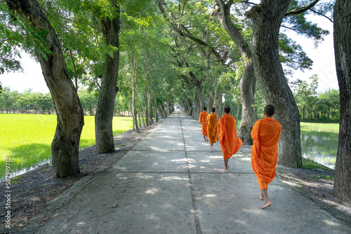 Monks with begging bowls beneath saffron robes go out in the morning in West Vietnam