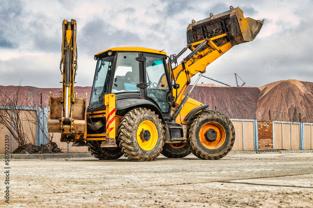 The universal backhoe loader lifted up the bucket on the construction site. Rental of construction equipment for earthworks. Universal construction equipment. Excavation.