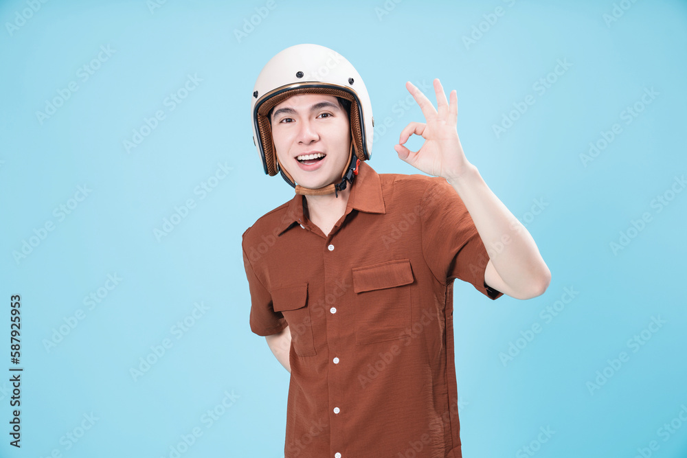 Young Asian man wearing helmet on background Young Asian man wearing helmet on background