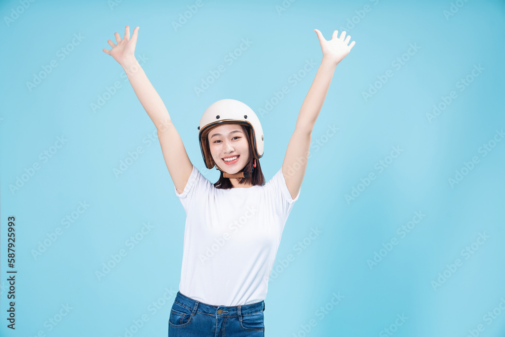 Young Asian woman wearing helmet on background Young Asian woman wearing helmet on background