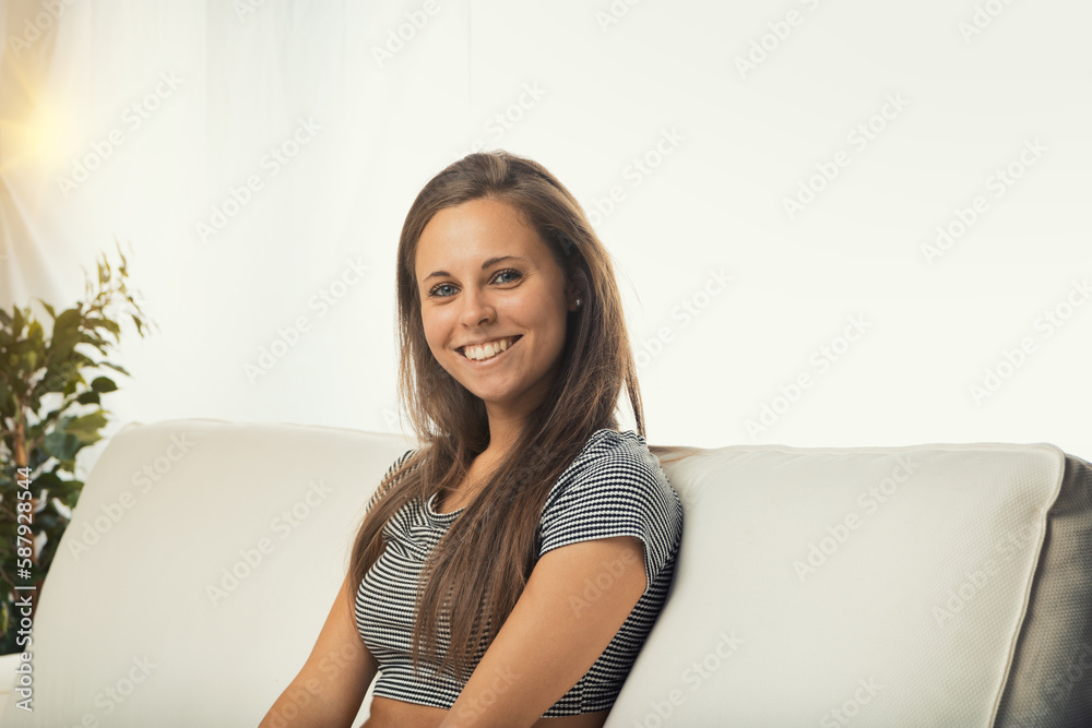 Young woman smiling on white sofa Young woman smiling on white sofa