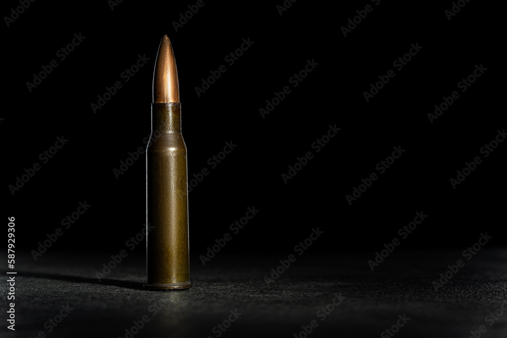 Rifle bullet long cartridge on black background. Army or hunting weapon shot object, violence and danger symbol. Rifle bullet long cartridge on black background. Army or hunting weapon shot object, violence and danger symbol.