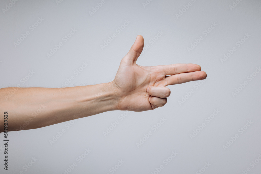 Man's hand showing gun gesture isolated over light background.