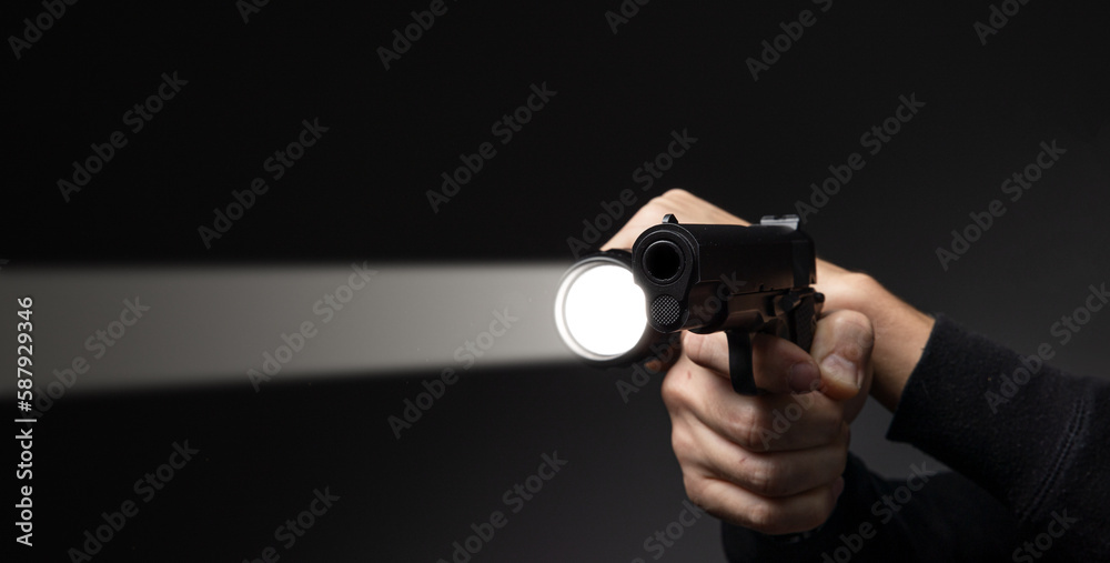 Professional security guard or policeman with flashlight and gun in dark room Professional security guard or policeman with flashlight and gun in dark room