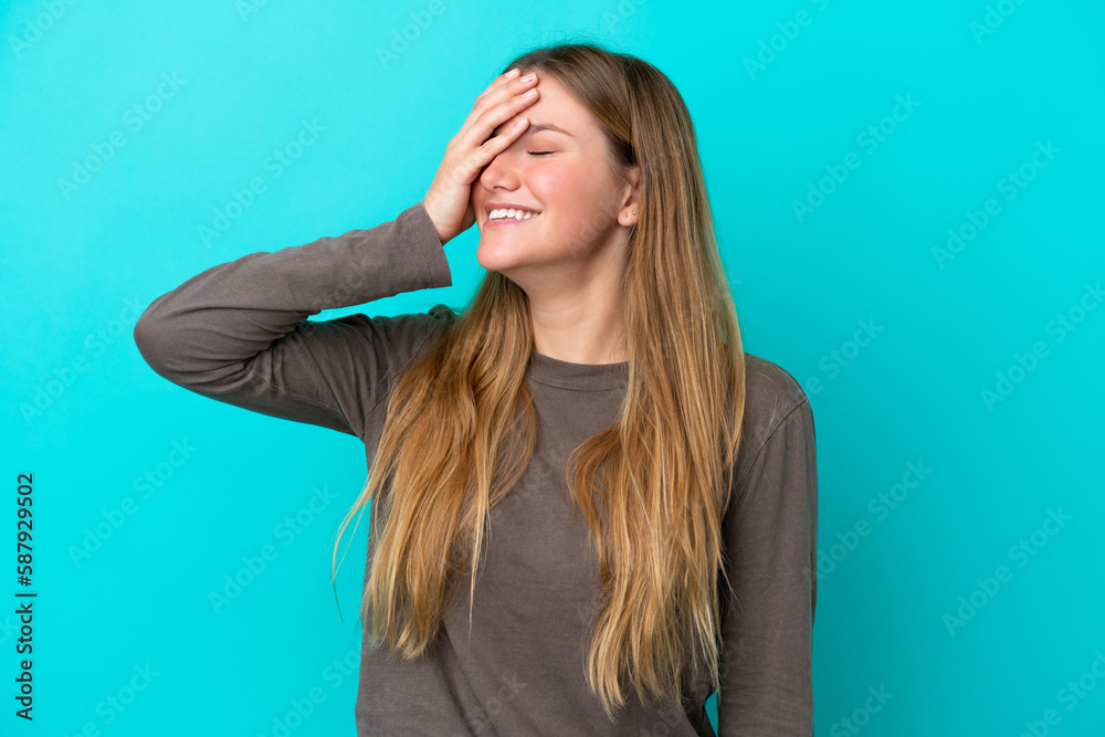 Young blonde woman isolated on blue background smiling a lot