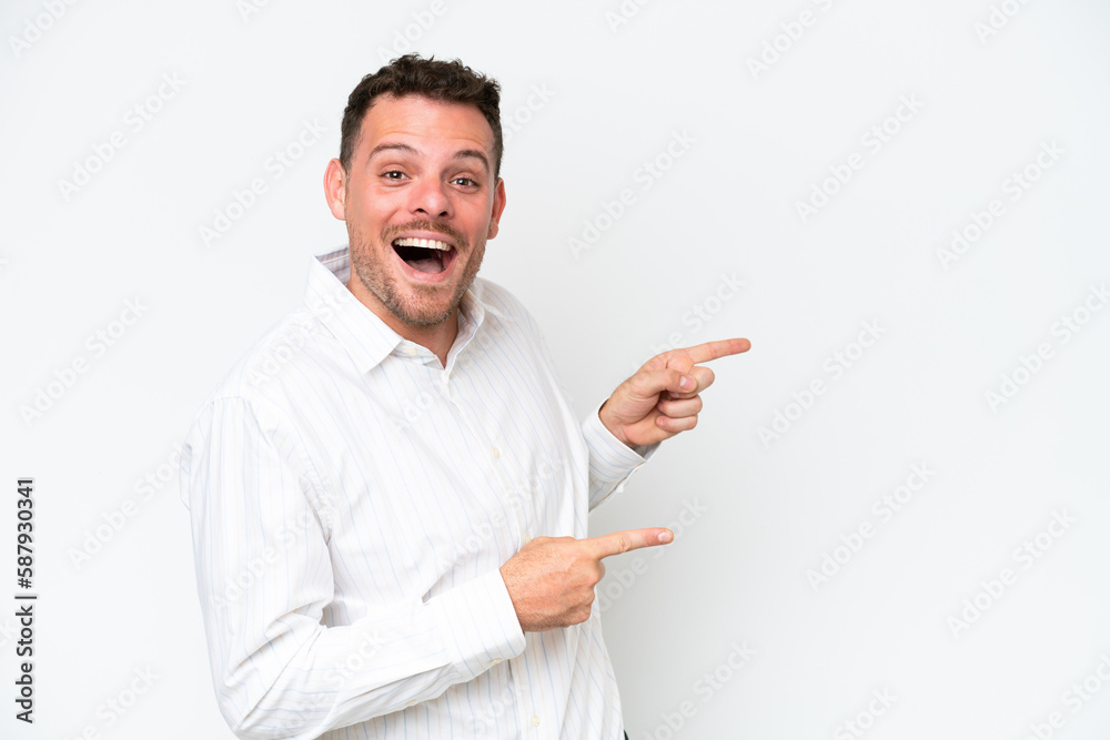 Young caucasian handsome man isolated on white background surprised and pointing side Young caucasian handsome man isolated on white background surprised and pointing side