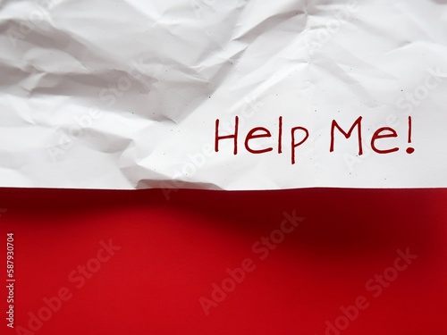 Crumpled paper on red background with text written HELP ME - Concept of asking for help when needed - persons concerned to be afforded the necessary support if required