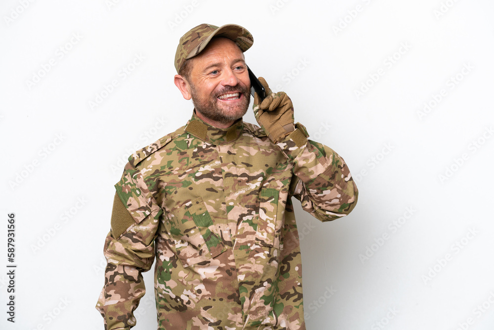Military man isolated on white background keeping a conversation with the mobile phone