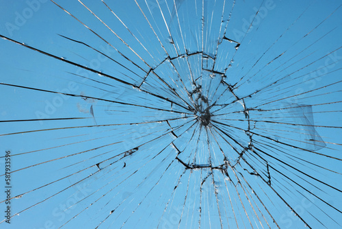 Broken glass, glass cracked from an accident on a blue sky background