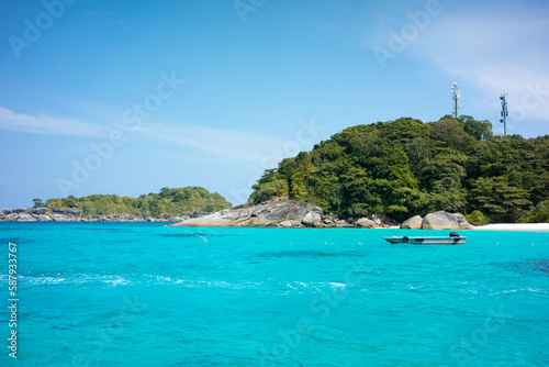 Tropical island of Andaman coast with turquoise and clear blue waters against blue sky.