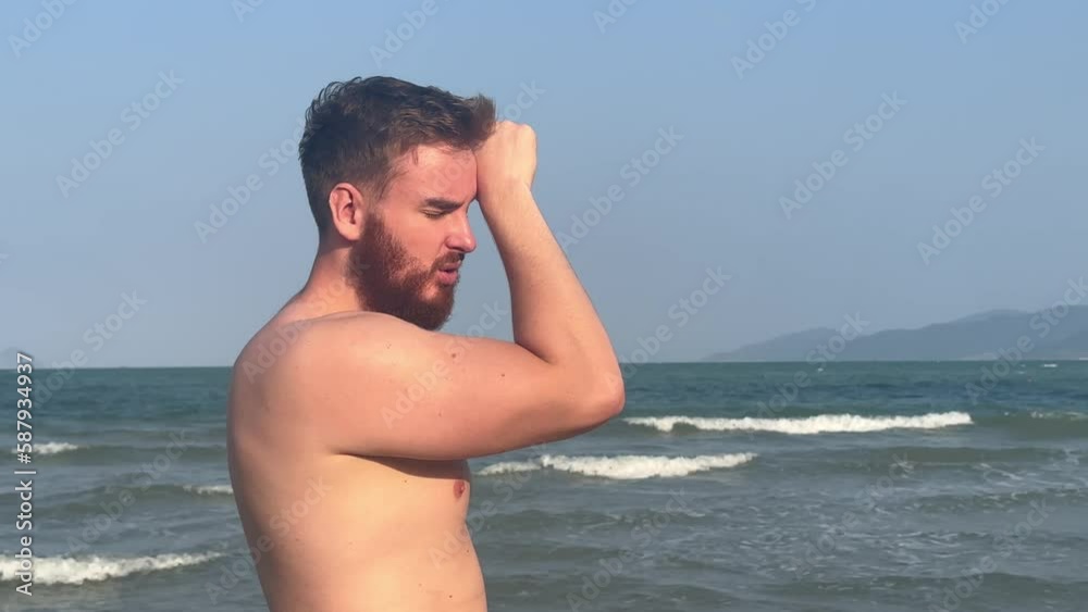 Guy is suffering from heat, man with heatstroke. Having sunstroke at summer hot weather. Dangerous sun, boy under sunshine. Headache, feeling bad. Person holds hand on head at sea, beach Guy is suffering from heat, man with heatstroke. Having sunstroke at summer hot weather. Dangerous sun, boy under sunshine. Headache, feeling bad. Person holds hand on head at sea, beach