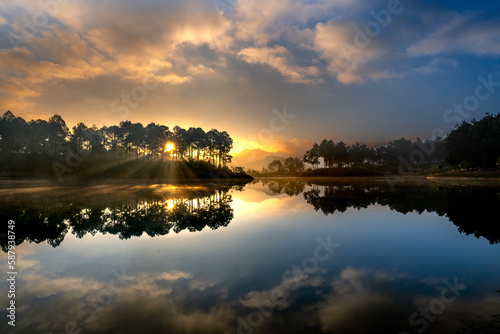 Beautiful dawn on the lake with pink clouds and reflecting sun rays at Ban Ang village, Moc Chau, Son La Province, Vietnam