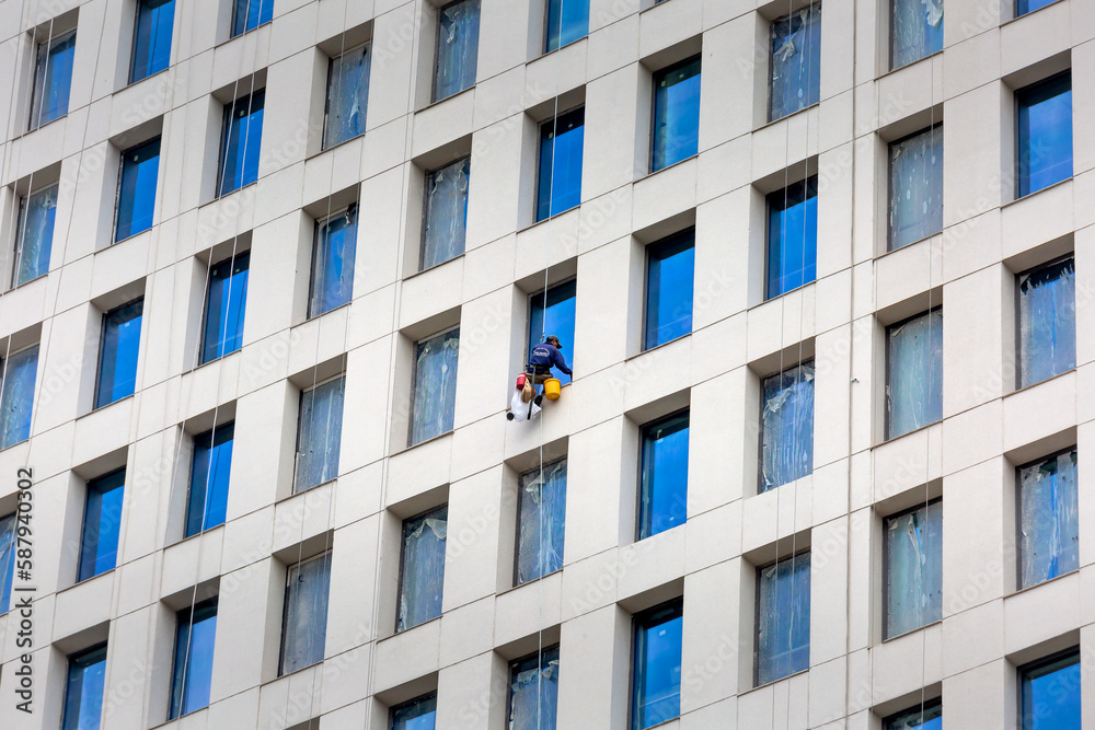Ho Chi Minh City, Vietnam - workers are cleaning the glass of an office building. This is a dangerous profession Ho Chi Minh City, Vietnam - workers are cleaning the glass of an office building. This is a dangerous profession