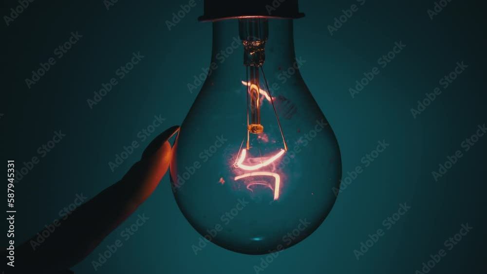 Light bulb turns on and goes out at the touch of a person's hand in the