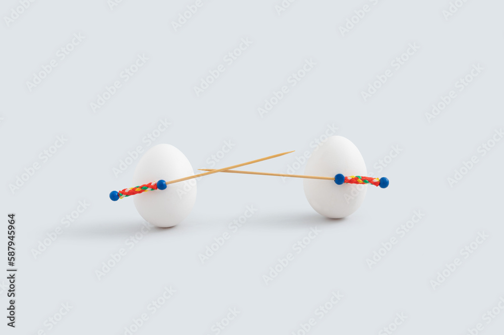 Minimal Easter concept with two white eggs and toothpicks used as spear or sword. Minimal Easter concept with two white eggs and toothpicks used as spear or sword.