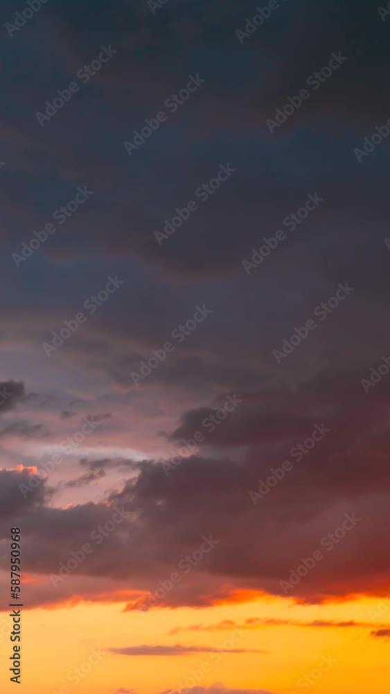 Vertical shot 4K Sunset Cloudy Sky With Fluffy Clouds. Sunset Sky Natural Background. Sunrays, sunray, ray, Dramatic Sky. Sunset Time Lapse Time-Lapse In Yellow, Day To Evening Transition.