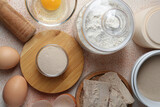 Different types of yeast, flour and eggs on orange textured table, flat lay