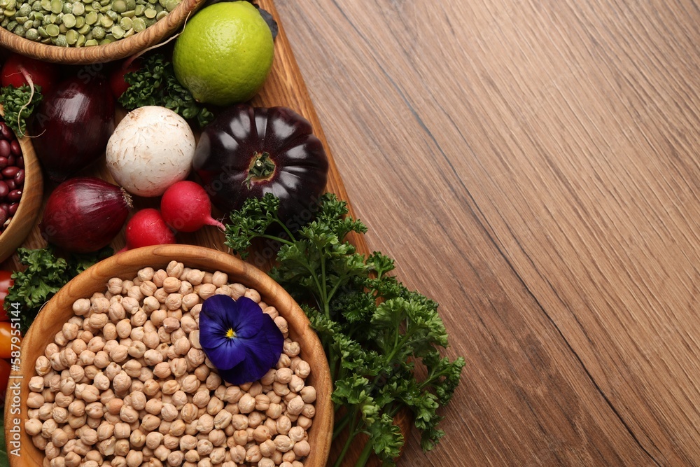 Fototapeta premium Different vegetables on wooden table, flat lay and space for text. Vegan diet