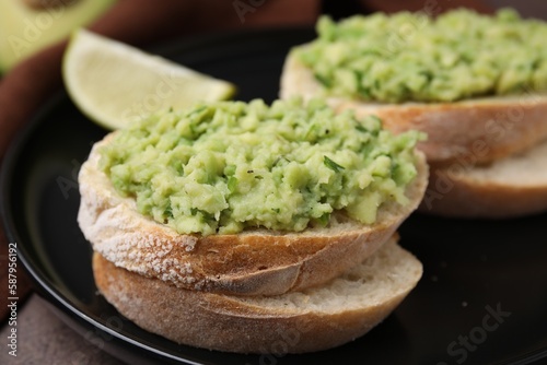 Delicious sandwiches with guacamole on black plate, closeup