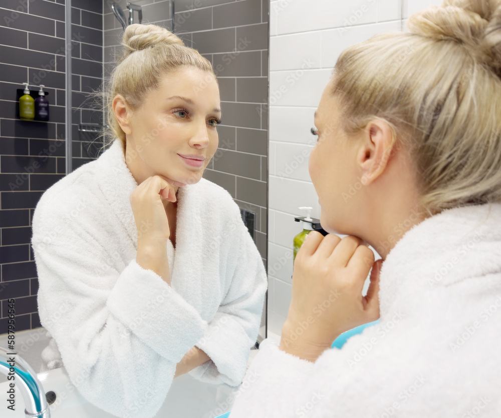 woman looking in the mirror in the bathroom and taking care of her skin. woman looking in the mirror in the bathroom and taking care of her skin.