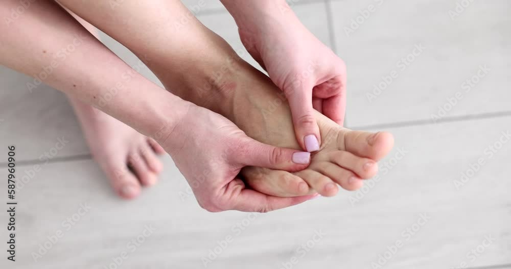 Woman doing foot massage with hands at home closeup 4k movie slow