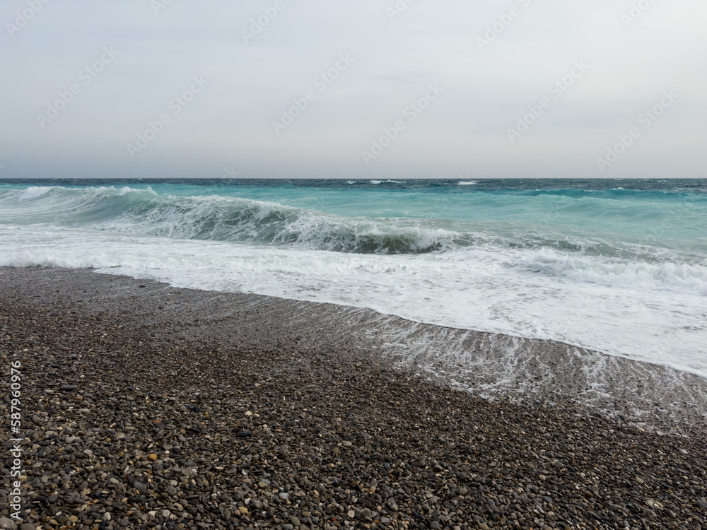 Pebble beach of Nice, France with azure waves of mediterranean sea Pebble beach of Nice, France with azure waves of mediterranean sea