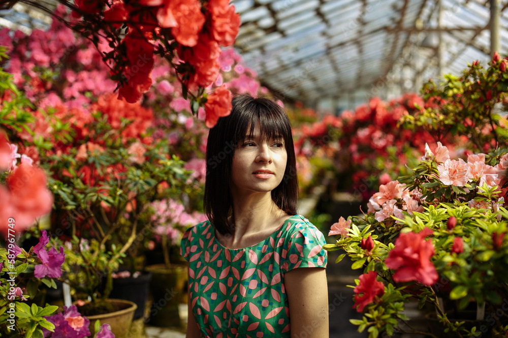 A girl in a green dress in a flower park on a sunny day