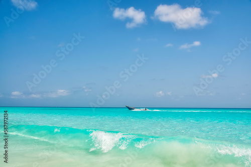 Fishing boat on the waves of the Indian Ocean in the emerald water.