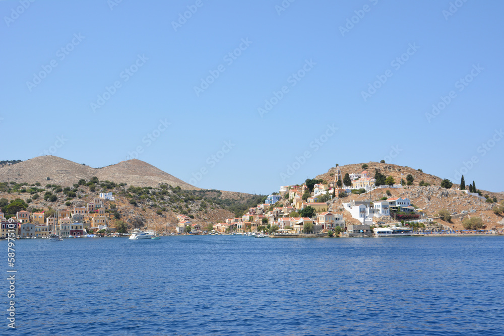 A view of the greek island Symi with boats and buildings from the water 