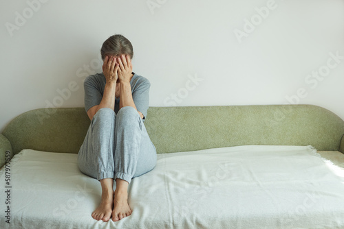 Melancholic mature woman crying covering her face