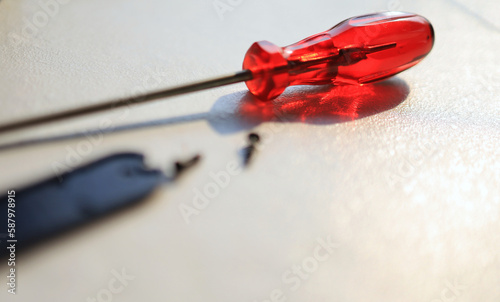 transparent red screwdriver handle Placed in the sun reflecting red light on the white floor.